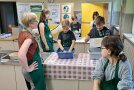 Frauen und Kinder stehen an Arbeitsplatte mit Plastikschüsseln