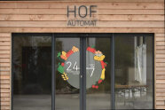 Eingang eines Hofladens mit Glastür und Aufschrift Hofautomat 